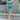 Full body front view of model wearing the Get Obsessed Skort in Teal that has teal fabric, a mini length hem, shorts lining, and an overlapped waistline.