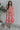 Full body view of model wearing the Secret Garden Midi Dress which features purple, red, orange, pink, yellow, green, teal and white fabric, floral print, midi length, flare hem, square neckline, short puff sleeves and smocked back.