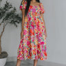 Full body view of model wearing the Secret Garden Midi Dress which features purple, red, orange, pink, yellow, green, teal and white fabric, floral print, midi length, flare hem, square neckline, short puff sleeves and smocked back.