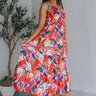 Full body view of model wearing the Good Vibes Multi Dress which features orange, red, pink, blue, green and cream fabric, geometric swirl print, pink lining, three-tiered body, ruffle detail, round neckline, tie straps and sleeveless.