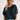 Frontal view of the Raw Moment Top that features a washed black fabric, a round neckline, a button-up front, a half sleeve, and a raw bottom hem.