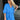 Frontal view of the Comfort Zone Dress that features a blue colored material, a round neck with a ruffle trim, a V neckline with an adjustable tie closure, a 3/4 sleeve, a tiered design, and a mini length.
