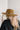 The Blame My Roots Hat is a wide brim hat featuring a camel colored fabric and a silver belt, finished with adjustable ties within for different fits.