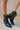 Front/ Side view of the Zane Western Bootie features a black leather upper, an almond toe, western inspired embroidery through out, side pull tabs for easy entry/exit, and a 3" block heel.