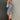 Frontal view of the Falling For You Dress that features a cotton material, an ivory and black plaid print, a collar neckline, a button-up front, a long cuffed sleeve, a front pocket, and a mini length