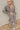 Frontal view of the Still Blooming Top that features a taupe material, a brown floral print, a collar neck, a button-up front, a long cuffed sleeve, and a lettuce edge hem