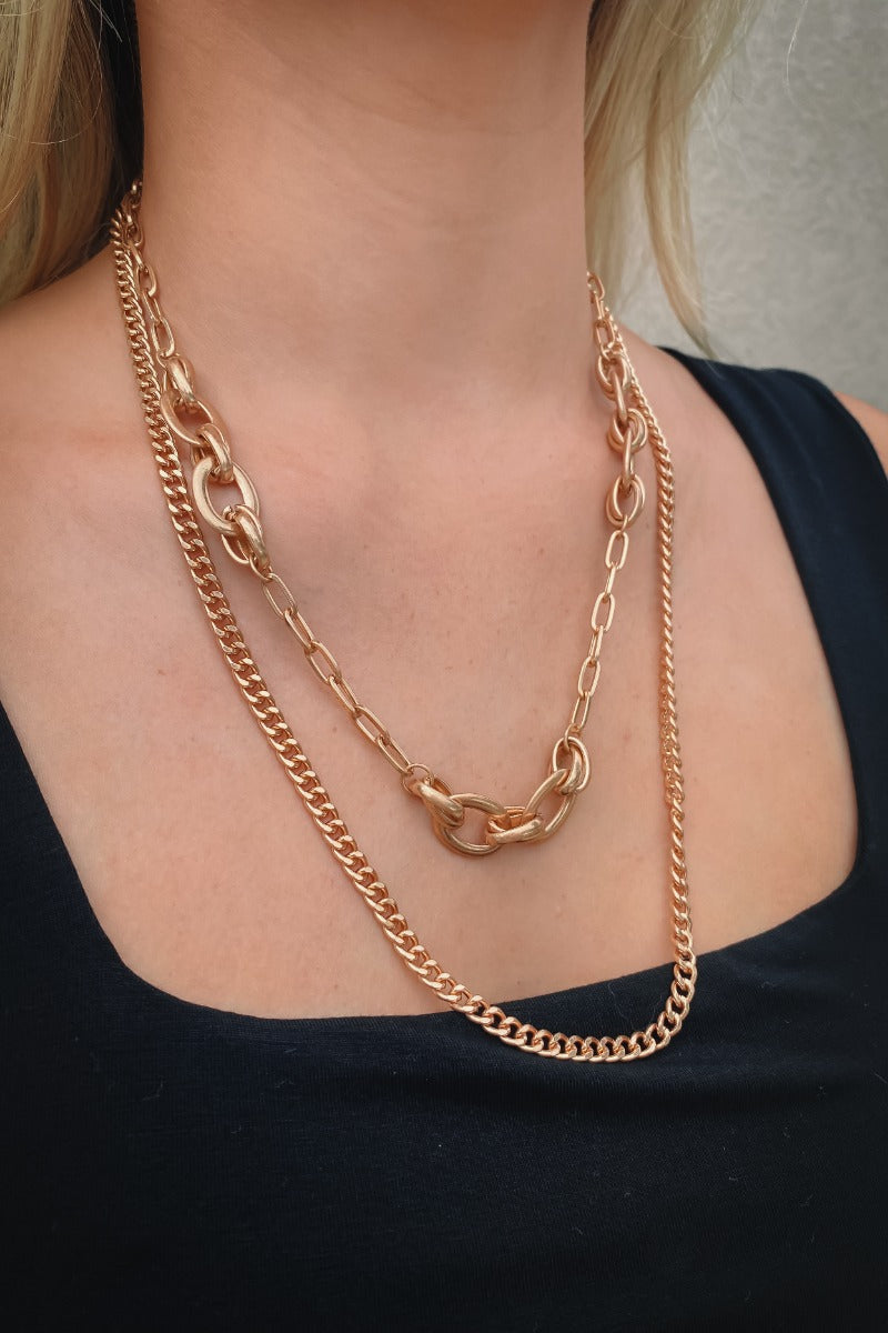 The Everyday Duo Necklace is a double layered necklace, featuring a gold chain and a gold chain link finished with an adjustable link and clasp closure.