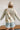 Back view of the Fast Forward Sweater that features an ivory knit material with a taupe design, a round neckline, a long sleeve, and an oversized fit.