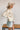 Side view of the Fast Forward Sweater that features an ivory knit material with a taupe design, a round neckline, a long sleeve, and an oversized fit.