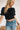 Frontal view of the Cool and Classy Top that features a black colored material, a round neckline with a lace trim, a half sleeve, a smocked body, a ruffle trim, and a back button closure.
