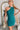 Frontal view of the Tell Me About It Dress that features a teal ribbed material, a high round neckline, a sleeveless design with one shoulder thick strap, a tight fit, and a mini length.