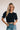 Frontal view of the Cool and Classy Top that features a black colored material, a round neckline with a lace trim, a half sleeve, a smocked body, a ruffle trim, and a back button closure.