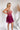 Side view of the Pinky Promise Mini Dress that features a tulle material, a monochromatic tiered design, a straight neckline, a sleeveless design with thin adjustable straps, a back zipper closure, and a mini length.
