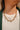 The Meet Me In The Middle Necklace In Green is a multi-layered necklace featuring green jewel pendants through out finished with a link and clasp closure.