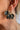 The Main Character Moment Earring is a gold, hoop style earring featuring eight black and gold dangle pendants shaped like a shell.