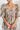 Frontal view of the Whimsy Dress that features a mesh material with a blush lining, a pink multi-colored floral design, a straight neckline, a 3/4 sleeve, a back zipper closure, and a mini length