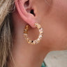 The Better Together Earring is a clear acrylic hoop style earring featuring gold and multi-colored specs through out.