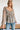 Frontal view of the Above All Else Top that features a blue colored material with a multi-colored floral print, a V neckline, a long sleeve, a ruched bust, and a flowy fit.