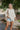 Front view of model wearing the Coast To Coast Sweater, which features a cream knit material with diamond stitching, a scoop neck, an oversized 3/4 sleeve, a thick bottom hem, and an oversized fit.