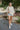 Full body front view of model wearing the Coast To Coast Sweater, which features a cream knit material with diamond stitching, a scoop neck, an oversized 3/4 sleeve, a thick bottom hem, and an oversized fit.