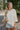 Front view of model wearing the Coast To Coast Sweater, which features a cream knit material with diamond stitching, a scoop neck, an oversized 3/4 sleeve, a thick bottom hem, and an oversized fit.