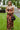 Frontal view of the What's New Midi Dress that features a copper colored silk material, a black abstract print, a V neckline, a sleeveless design with thin adjustable straps, a side slit, and a midi length.