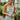 Frontal view of the Endless Nights Midi Dress that features a white silk material, a sage green swirl print, a cowl neckline, a sleeveless design with thin adjustable straps, a side slit, and a midi length.