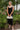 Frontal view of the Call You Mine Midi Dress that features a black colored silk material, a cowl neckline, a sleeveless design with thin adjustable straps, a side slit, and a midi length.