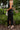 Side view of the Call You Mine Midi Dress that features a black colored silk material, a cowl neckline, a sleeveless design with thin adjustable straps, a side slit, and a midi length.