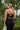 Back view of the Call You Mine Midi Dress that features a black colored silk material, a cowl neckline, a sleeveless design with thin adjustable straps, a side slit, and a midi length.
