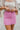Frontal view of the Think Pink Skirt that features a pink tweed material, a faux button-up front, a back zipper closure, and a mini length.