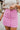 Frontal view of the Think Pink Skirt that features a pink tweed material, a faux button-up front, a back zipper closure, and a mini length.