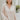 Frontal view of the On To The Next Top that features a champagne satin material, a collar neckline, a long sleeve with feather detailing at the cuff, a button-up front, and a flowy fit.