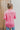 Back view of the All Things Lucky Top that features a pink colored material, a collar neckline, a button-up front, a long cuffed sleeve, and a front pocket.