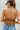 Back view of the A Little Drama Top that features a brown colored tulle material, a halter neck with an adjustable tie, an elastic top hem with ruffle details, a ruffle bottom, and an open back.