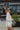 Side view of the Where To Next Top that features a soft cream material, a round neckline, a long cuffed sleeve, two side slits, and a thick bottom hem.