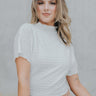 front view of model wearing the Now And Forever Top that has ivory textured fabric, a cropped waist, lettuce trim, a high neckline and short sleeves