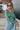 Front close up view of model wearing the On Your Mind Top in Green which features light green knit fabric, cropped waist, round neckline and long sleeves.