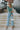 Full body view of model wearing the On Your Mind Top in Green which features light green knit fabric, cropped waist, round neckline and long sleeves.