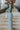 Full body side view of model wearing the On Your Mind Top in Green which features light green knit fabric, cropped waist, round neckline and long sleeves.