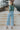 Full body back view of model wearing the On Your Mind Top in Green which features light green knit fabric, cropped waist, round neckline and long sleeves.