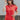 Front view of model wearing the Game On Romper which features washed red denim fabric, distressed details, two front pockets, one chest pocket, folded hem shorts, an elastic waistband in the back, a hidden zipper and button up closure, a collared neckline