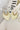The Don't Blame Me Earring is a dangle style earring, featuring gold detailing and an ivory palm shaped body.