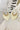 The Don't Blame Me Earring is a dangle style earring, featuring gold detailing and an ivory palm shaped body.