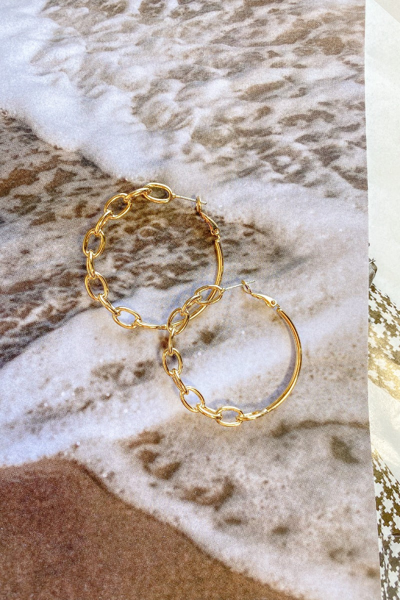 The Season After Season Earring is a gold hoop style earring, featuring a half chain link design.