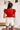 Back view of the Game-On Bodysuit that features a red ribbed material, a V neckline, a ruffled short sleeve, and a thong bottom with a snap closure.