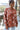 Front view of model wearing the Roam Free Cardigan, which features terracotta knit fabric with a blush floral print, a button-up front with a collar and brown tortoise buttons, two chest pockets, and long sleeves. Cardigan is worn half buttoned