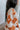 Side view of model wearing the Hello Sunshine Sweater, which features cream and orange knit fabric, orange ribbed trim, a large orange floral print, long sleeves, and an oversized fit