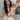 Front view of model wearing the Hello Sunshine Sweater, which features cream and orange knit fabric, orange ribbed trim, a large orange floral print, long sleeves, and an oversized fit