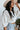 Side view of model wearing The Right Cord Top features lightweight cream-colored corduroy, a round neckline, 3/4 sleeves with elastic wrists, a keyhole button back, and a back zipper